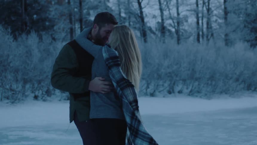 A man and woman dance around a frozen lake