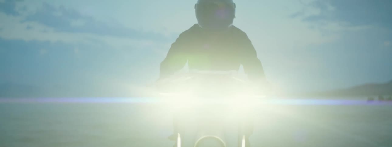 A man is riding a motorcycle while the sun is setting