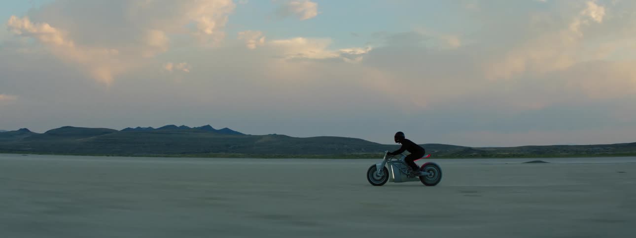 A person is riding a motorcycle through the wilderness