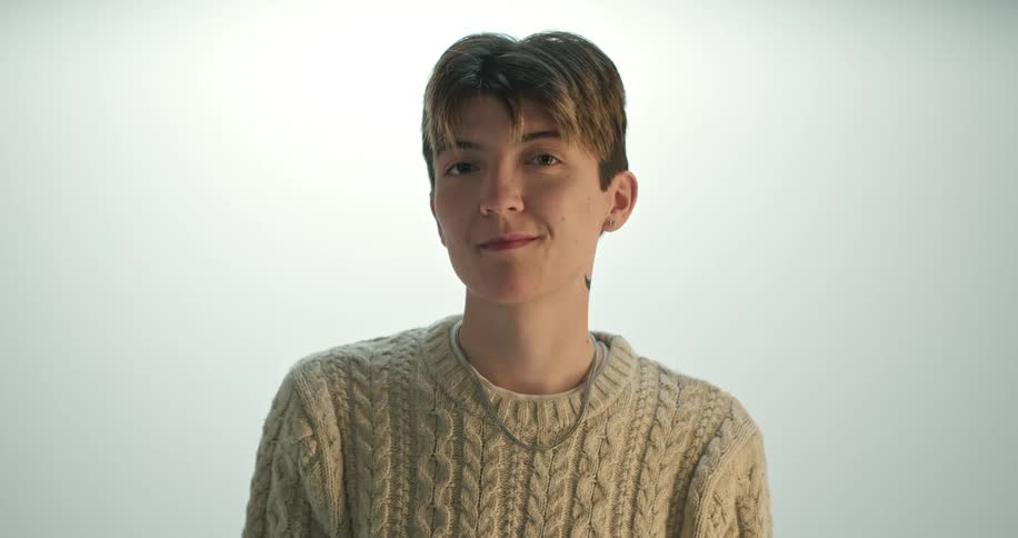 A woman is standing in front of a wall for a portrait