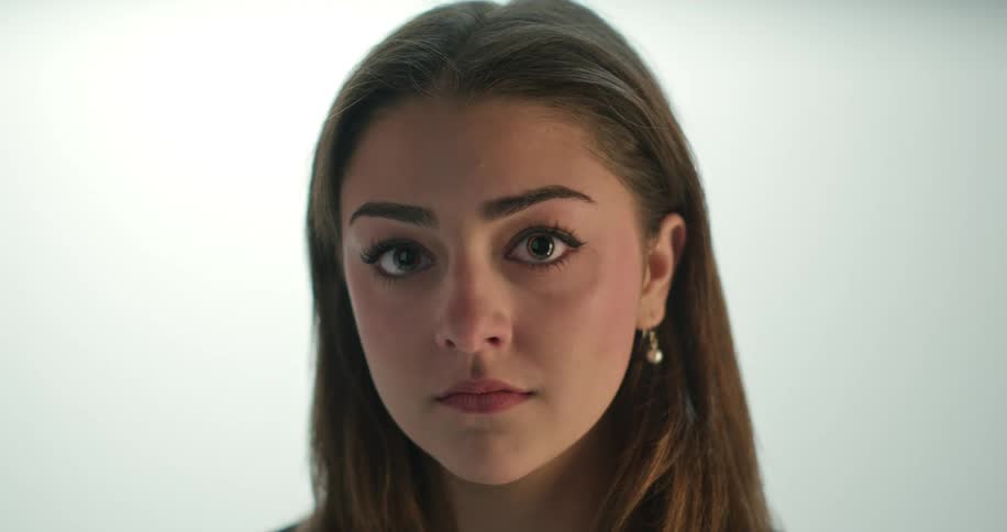 A young woman looks upwards at the camera while she is posing for a portrait