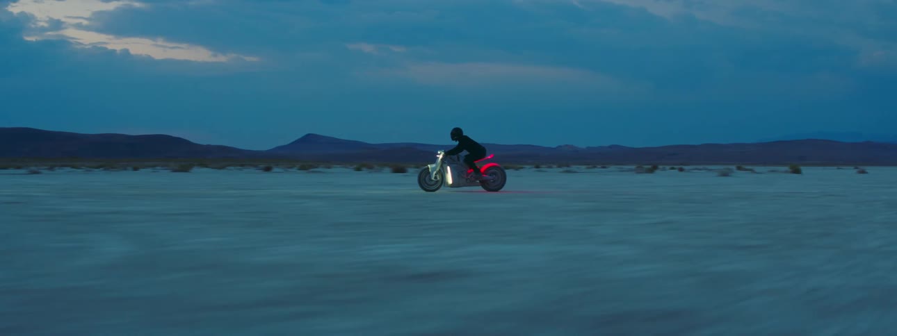A person races their motorcycle in the desert