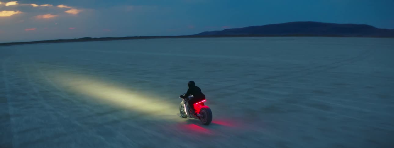 A person is riding a motorcycle through the desert at night