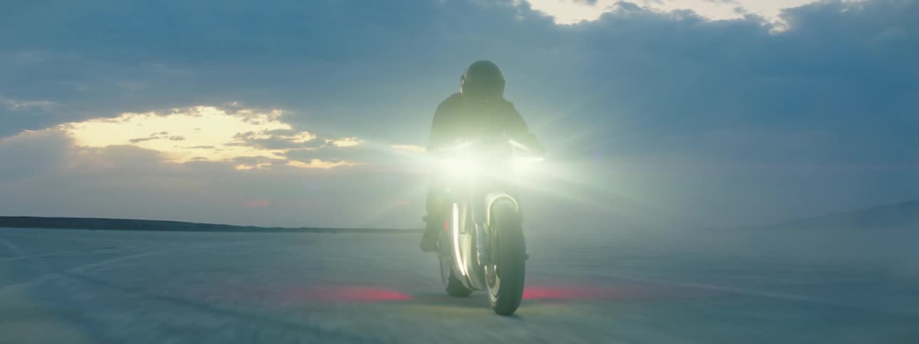 A man rides his motorcycle through the desert