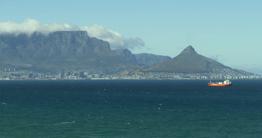 A kite surfer sails across False Bay with Cape Town and Table Mountain in the background