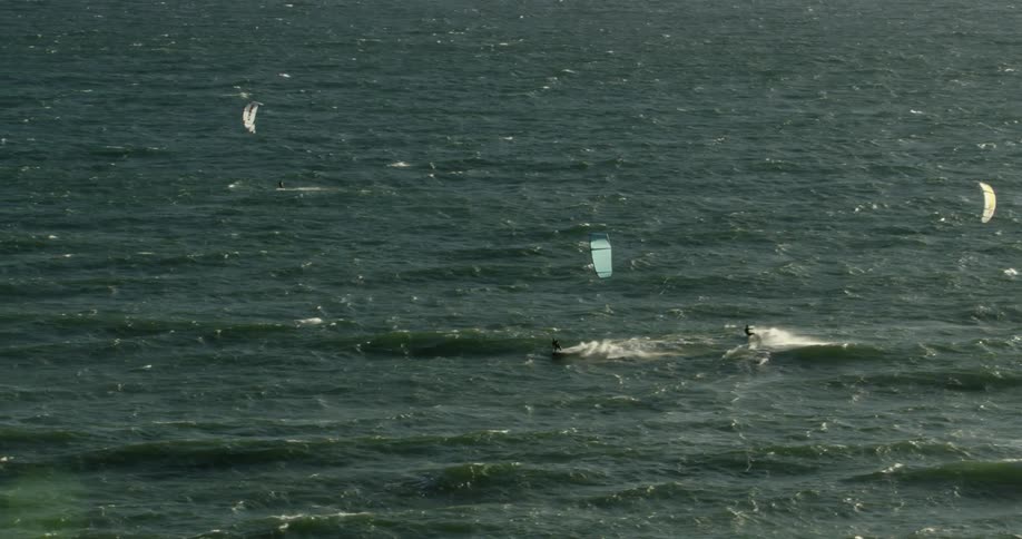 People kitesurfing on ocean waves