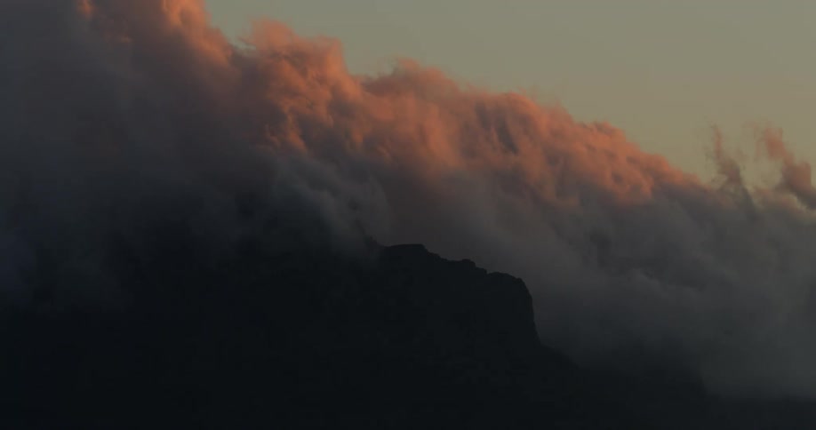 Clouds floating over Table Mountain landmark above the city of Cape Town at sunset