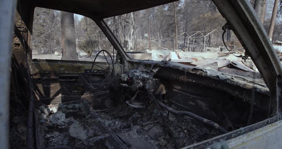 The car appears to have been severely damaged by fire with its metal frame twisted and blackened