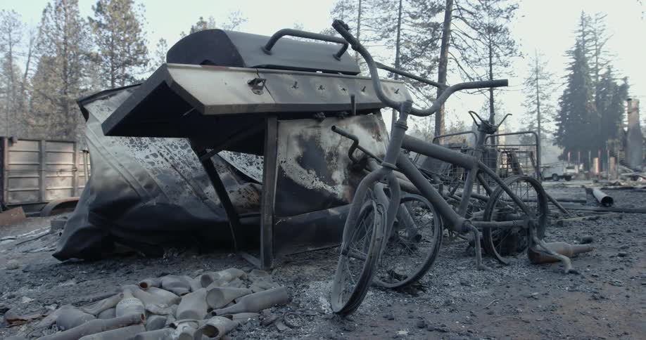 Burned remains of two bicycles a grill and other objects in the aftermath of a fire or explosion