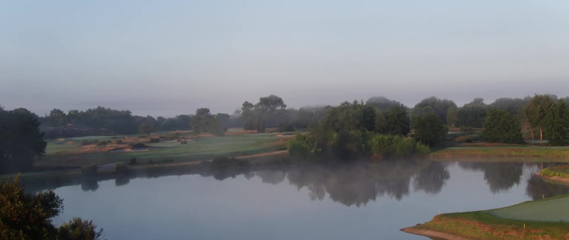 Surrounding trees reflect off a calm lake