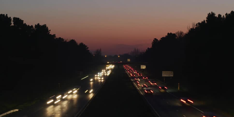 Traffic travels on the dark highway