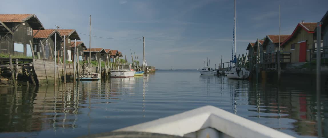 A boat traveling down a house and boat lined river