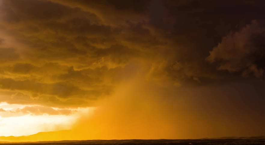 A desert landscape with clouds and dust rolling across the plains