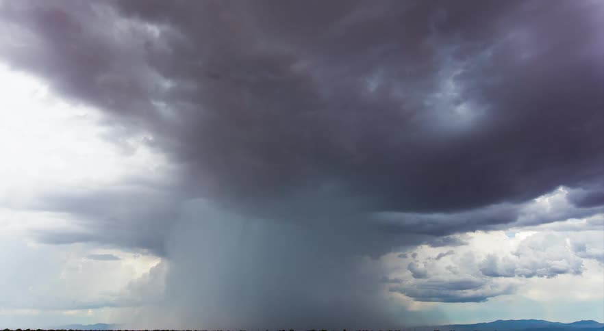 A strong downburst of rain explodes from a thunderstorm