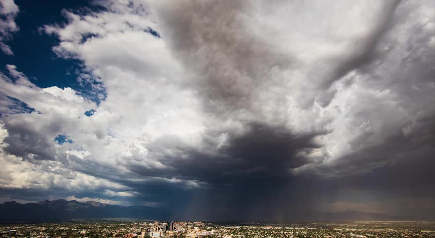 Wide shot of thunderstorm and dust moving over a city