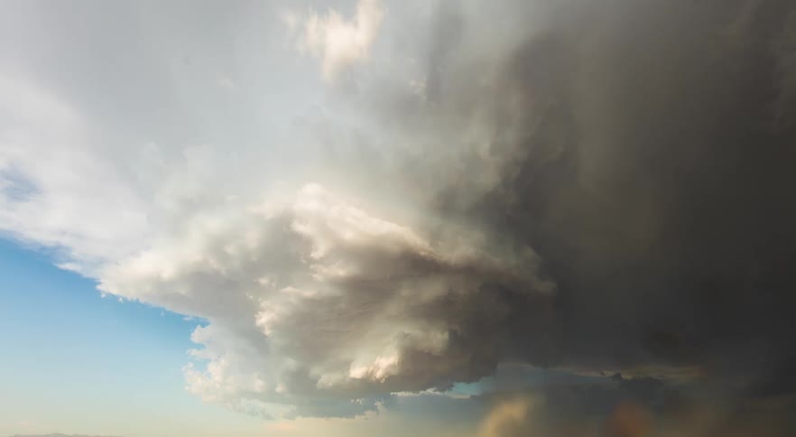 A large storm cloud is forming and swirling over flatland wilderness
