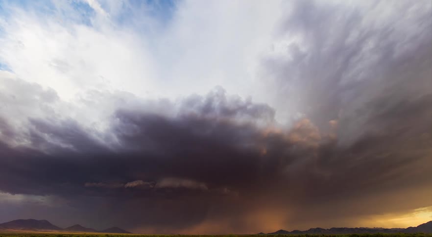 A supercell thunderstorm over the desert just before sunset