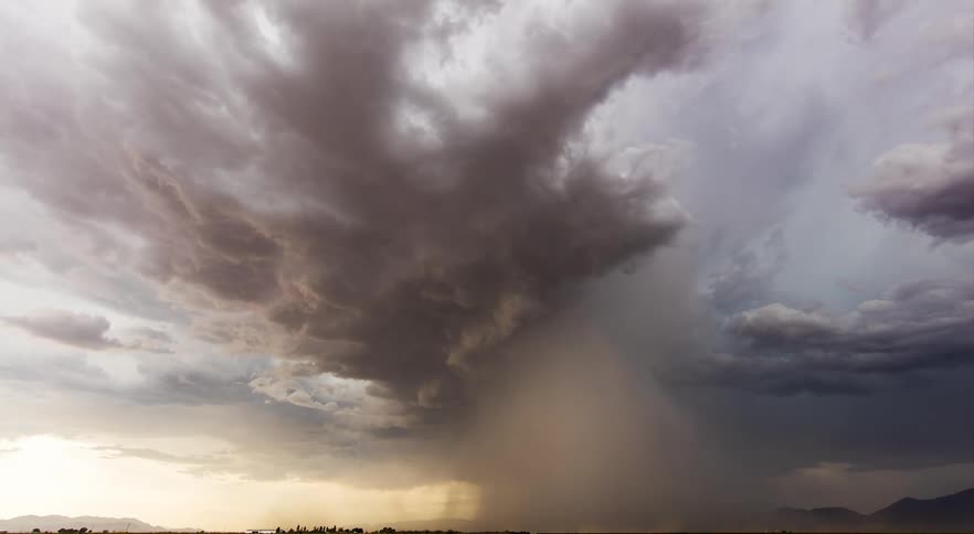 A thunderstorm causes strong blowing dust across farm lands