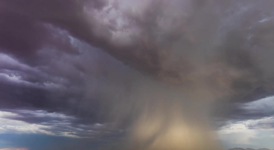Lightning is striking and rain is pouring from storm clouds over flatland