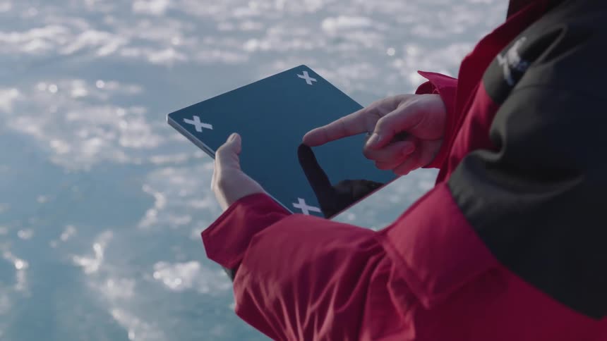 Man swipes on a tablet outside on a cold day