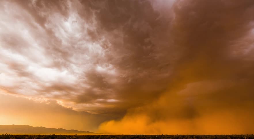 A desert dust storm traveling across the landcape