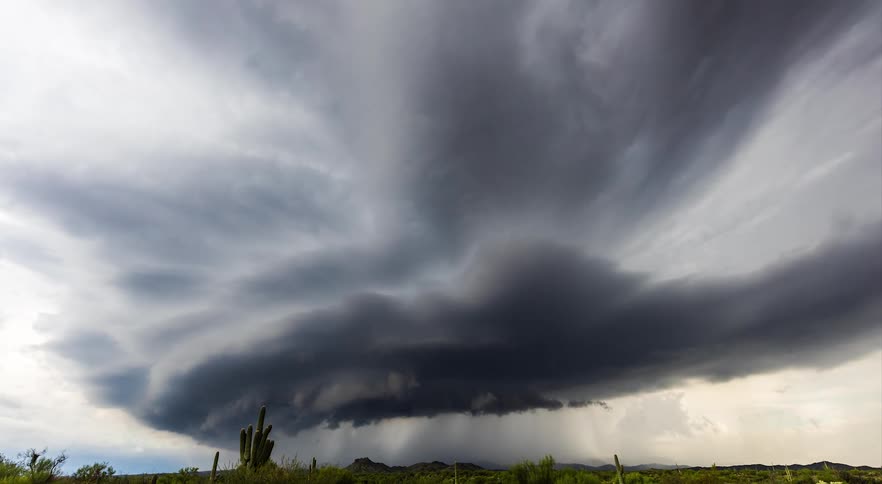 A supercell forms over a stunning desert landscape