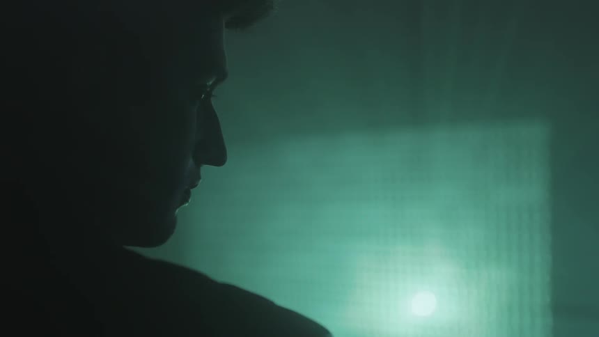A man looks at numbers projected on a wall