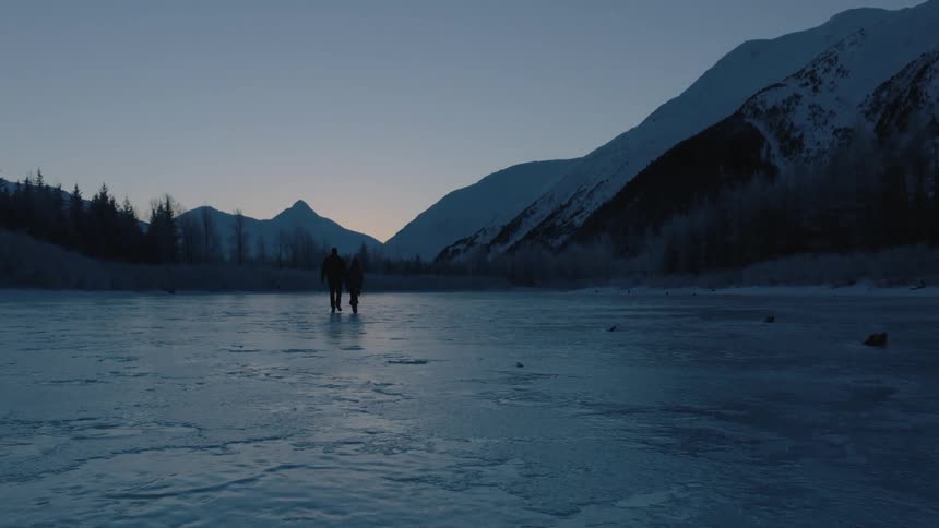 Two people are walking over the ice