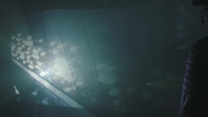 A man watches a projection on the wall