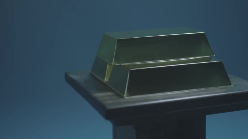 Three gold bars on a pedestal