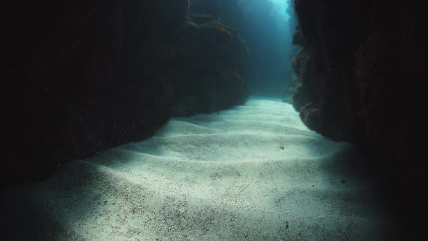 Sunlight shines on the seabed of an underwater cavern