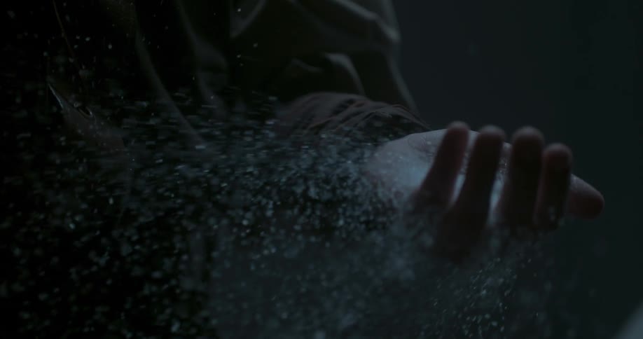 Sand blows out of a person's hand