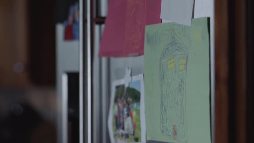 Childrens artwork covers the front of a familys fridge