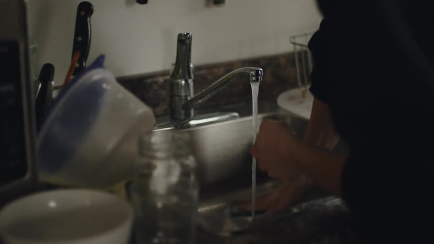 A person is washing dishes in their kitchen