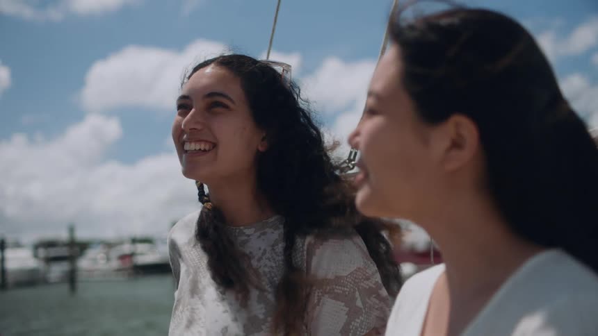 Friends chat while sitting on a boat docked at a pier