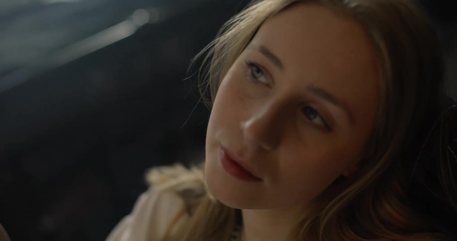 Blonde woman holding pen looks up and thinking