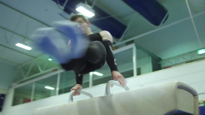 A gymnast spins around on a pommel horse