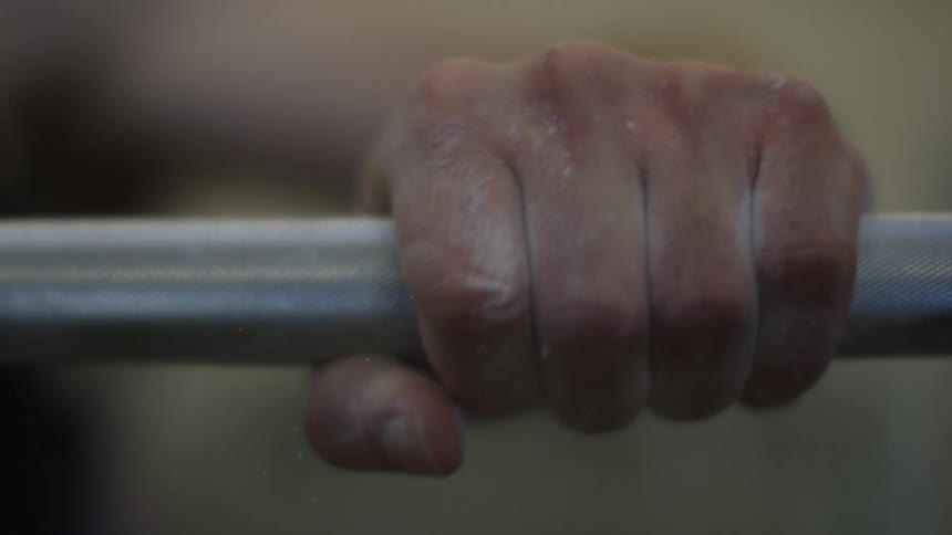 A man gripping a barbell while weightlifting