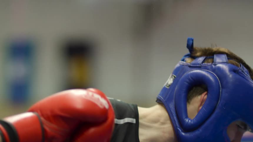 Boxer strikes his opponent in the ring