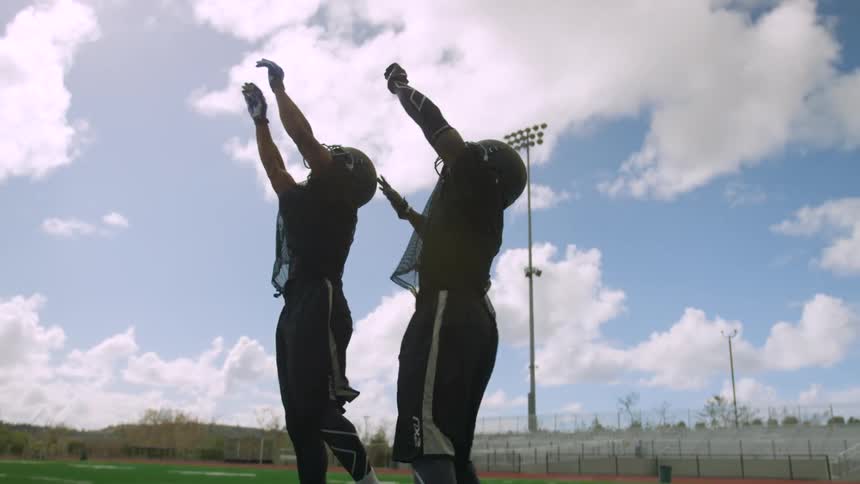 Two football players jump to catch the ball