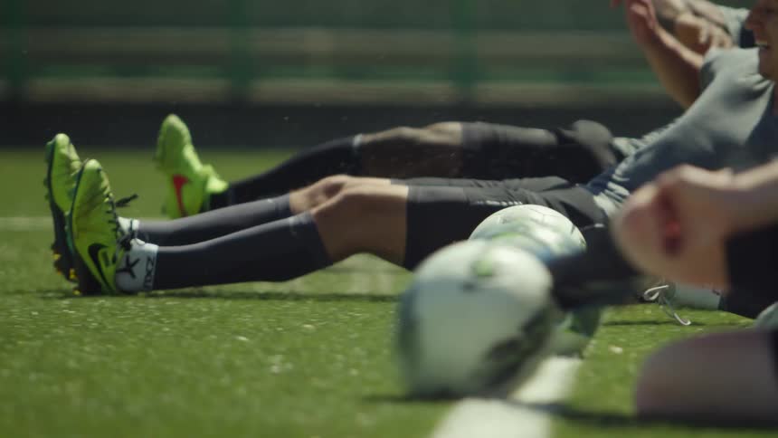 Soccer players run and slide to hit balls during training