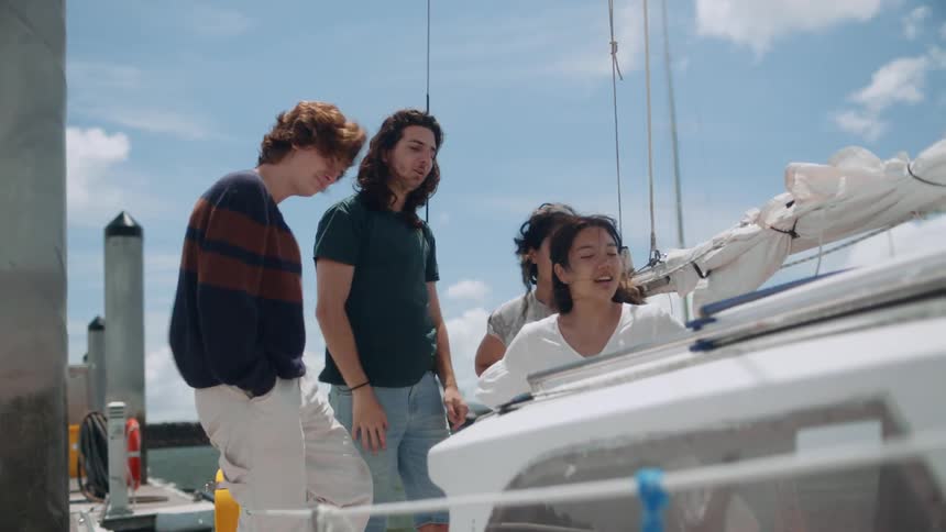Four young people on a sailboat at sea during the day