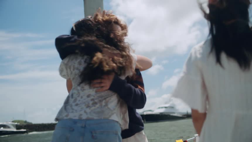 A group of friends are standing by a boat together