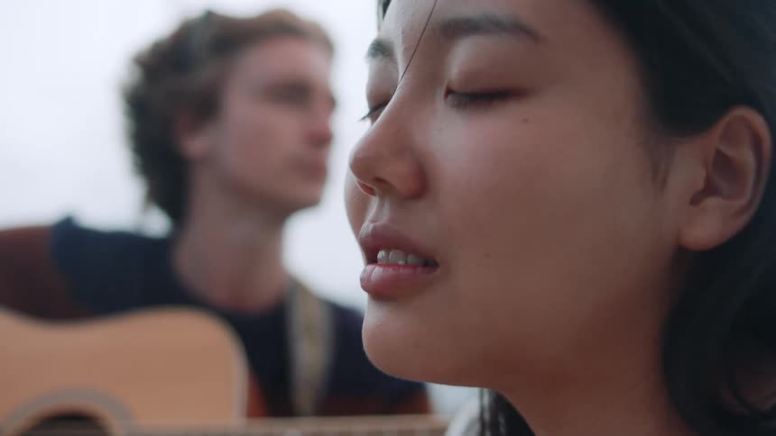 Male and female are playing guitar together