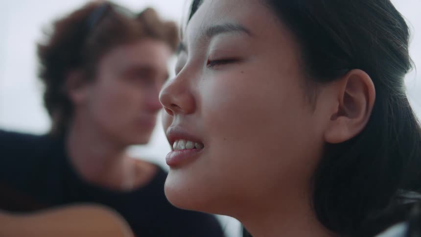 A man playing guitar while a woman listens
