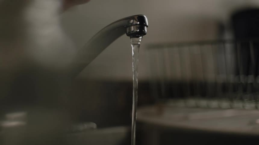A person is washing something in the sink