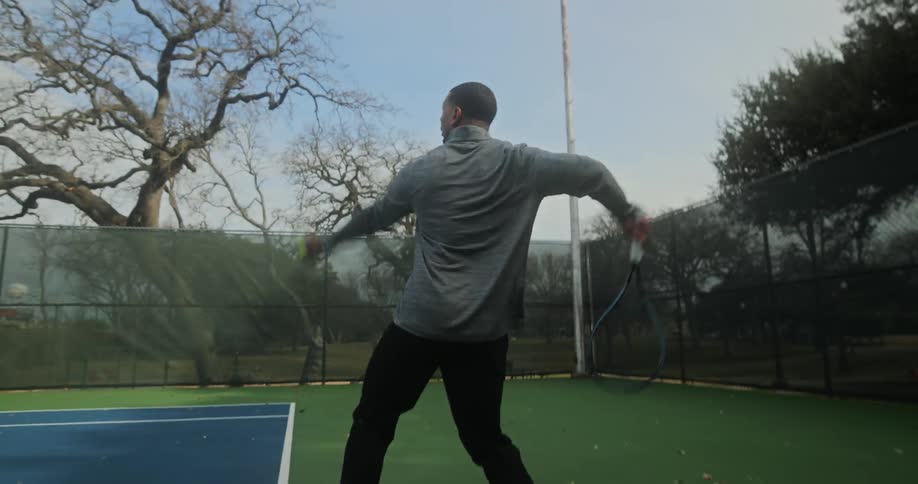 A man serves the tennis ball