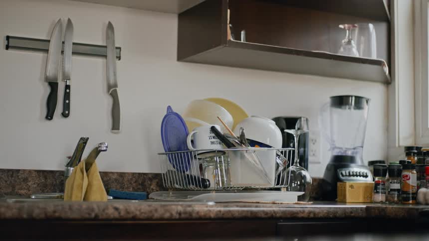 Stack of clean dishes drying on a rack on kitchen counter