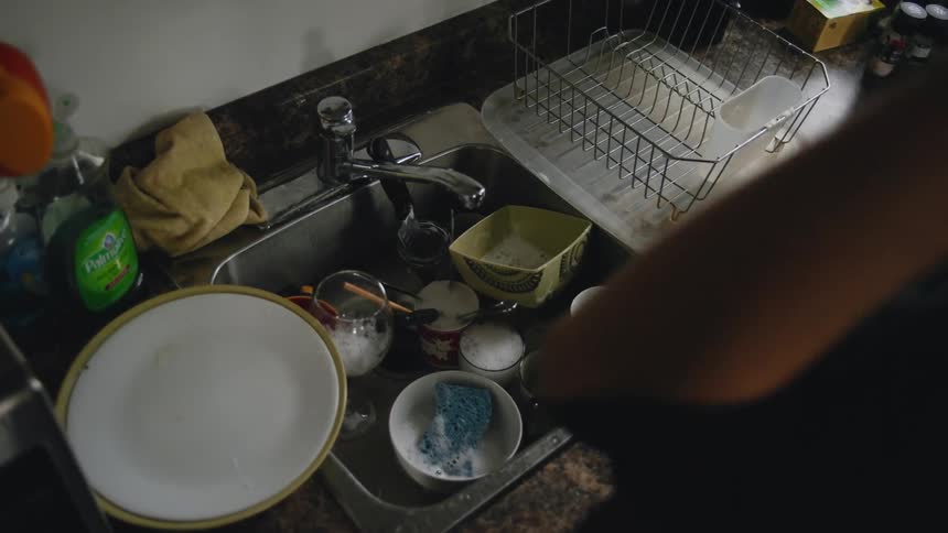 A person starts to wash dishes