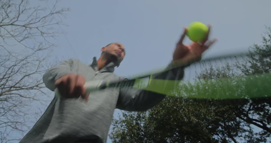 A man serves the tennis ball